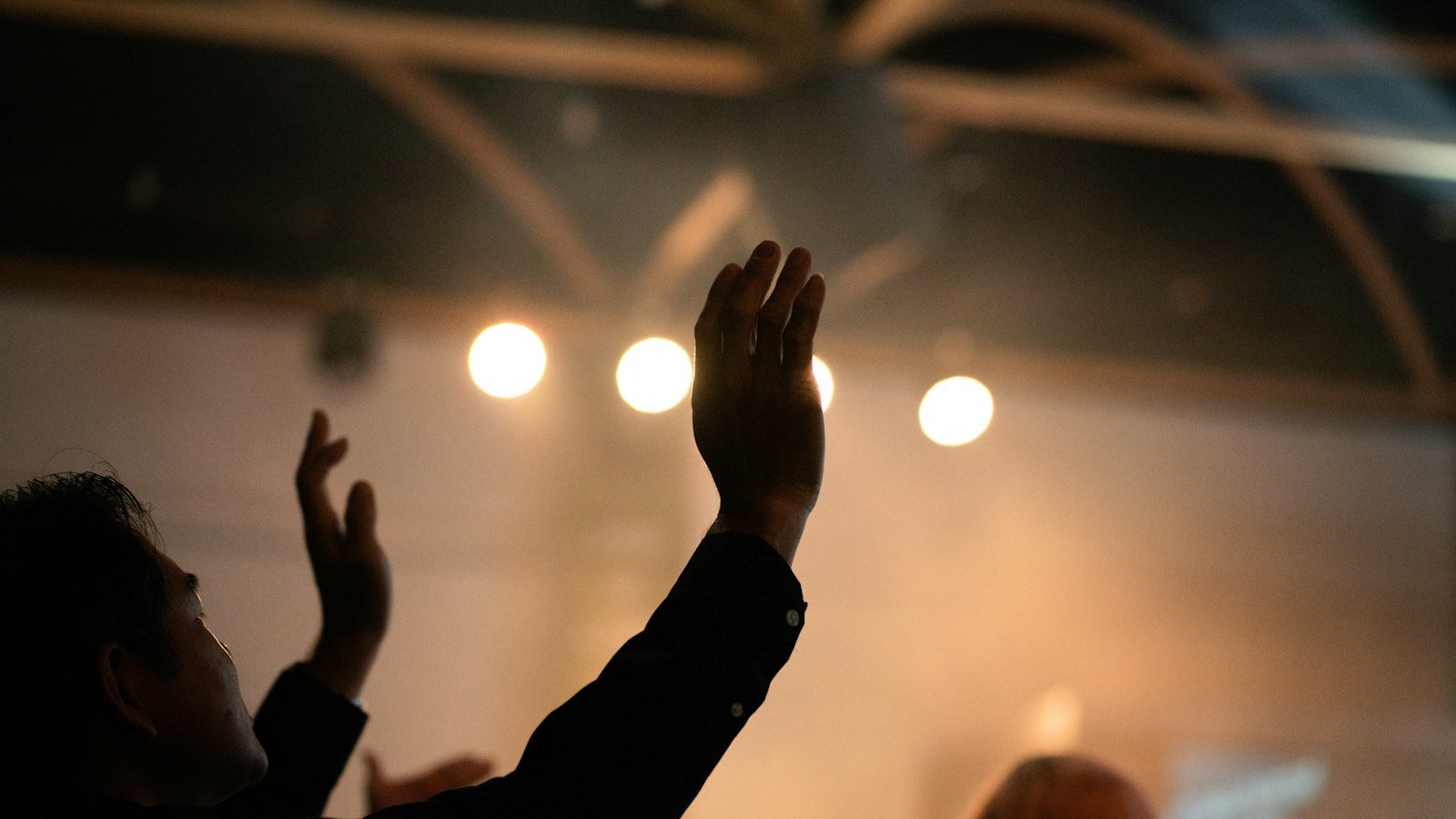 Goodbye Yesterday lyrics — worshipper with hands raised in praise under stage lights