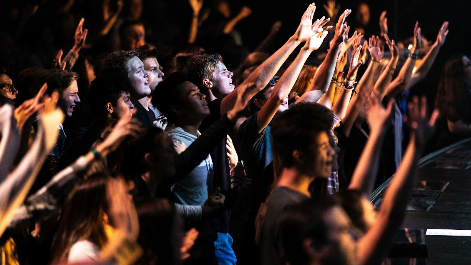 CeCe Winans Goodness of God lyrics — people raising their hands during a nighttime worship gathering