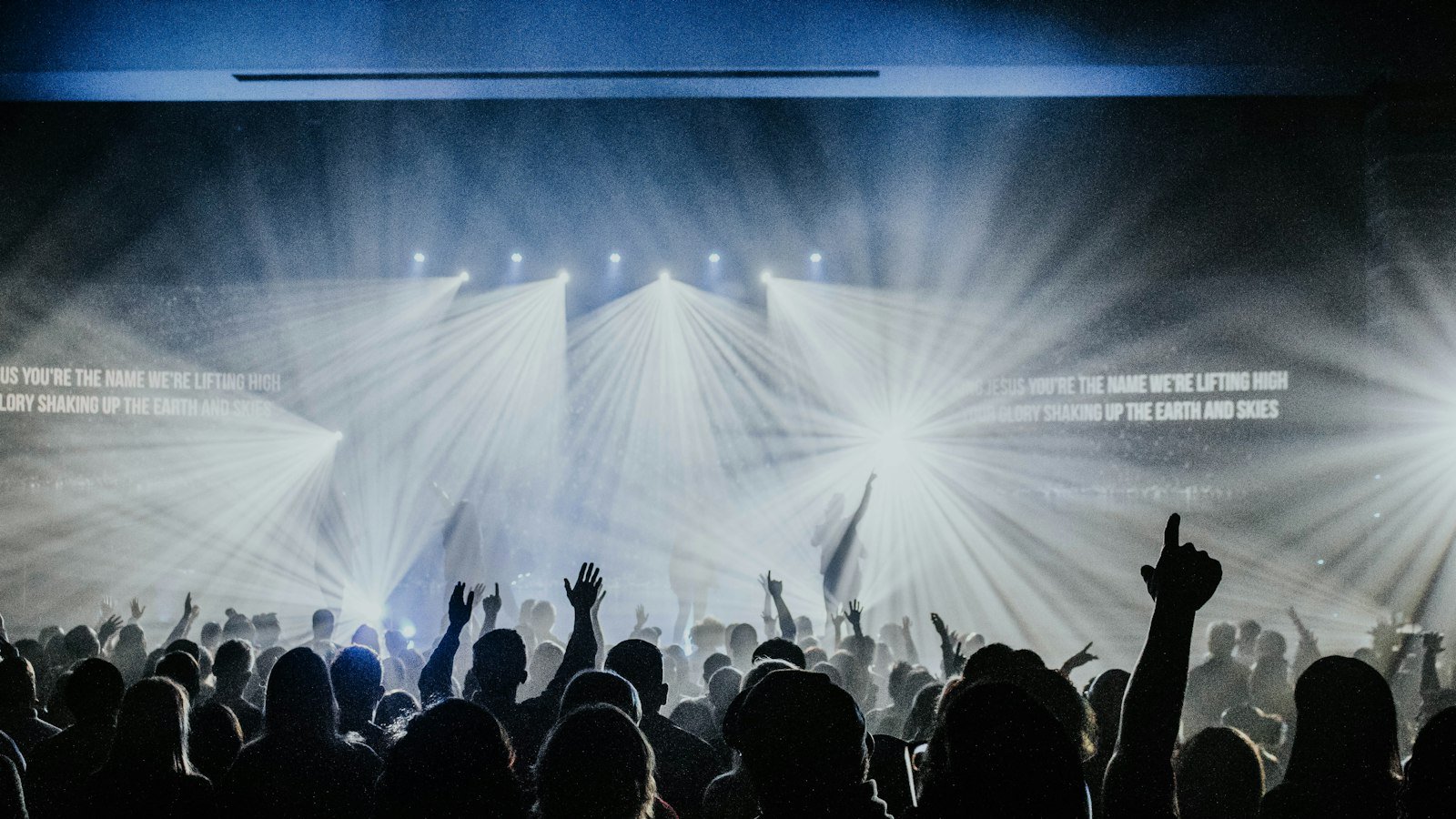 Promises Maverick City lyrics — church congregation watching a worship concert together