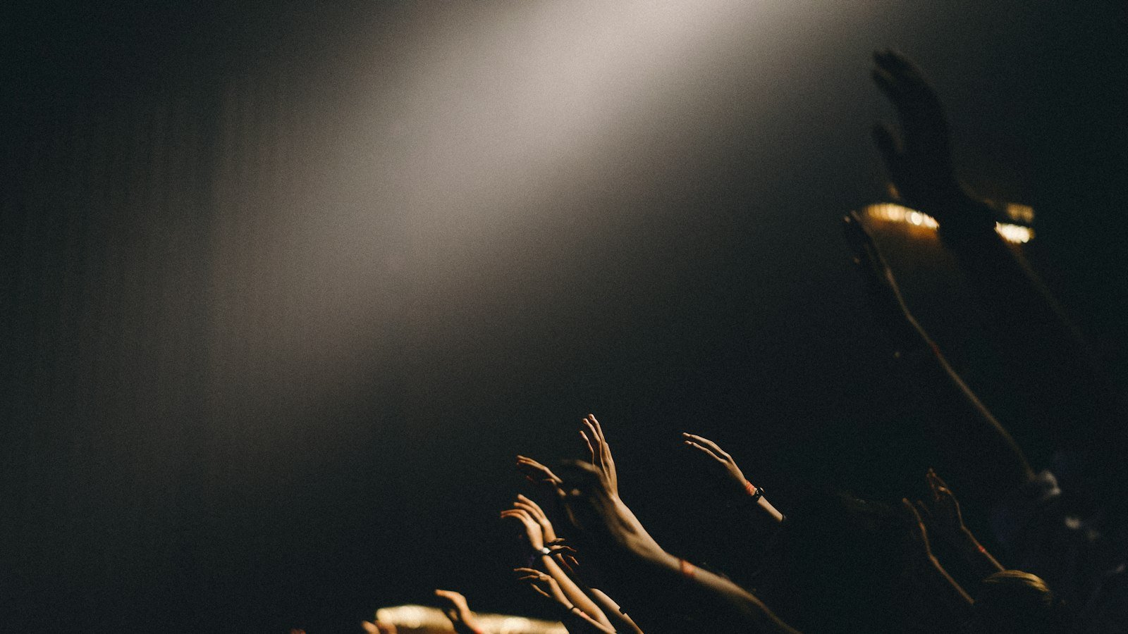 Promises Maverick City lyrics — worshippers waving their hands in praise during a concert